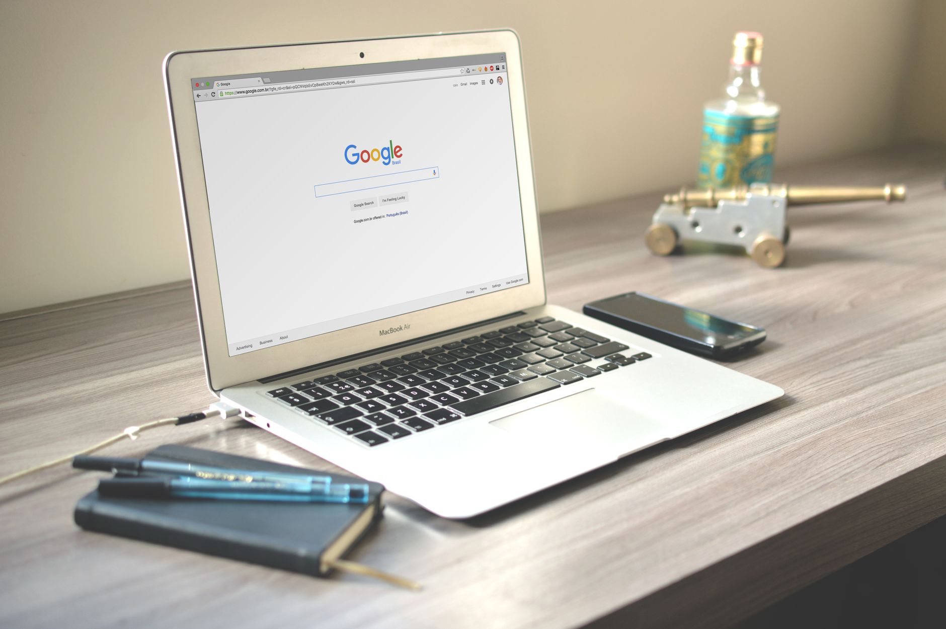 Browser viewer modes for exploration: A neat workspace featuring a laptop displaying Google search, a smartphone, and a notebook on a wooden